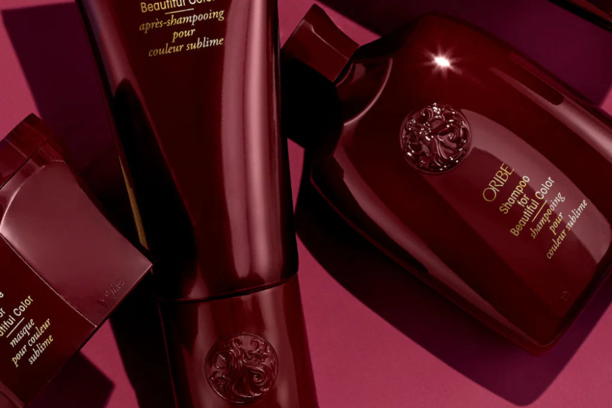 Oribe Beautiful Color Collection hair care products on a pink background