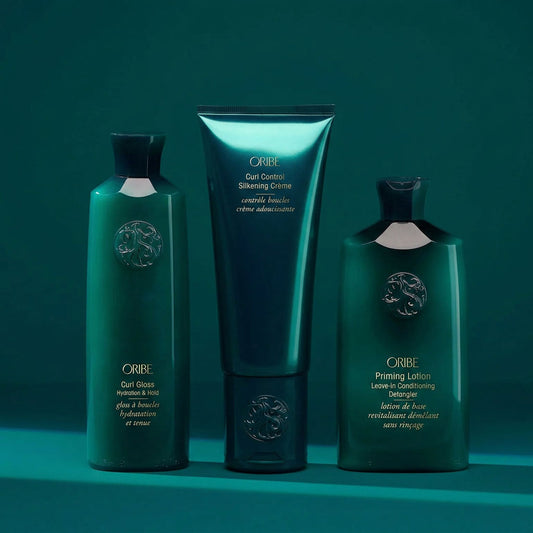 Oribe curl styling set including Curl Gloss, Curl Control Silkening Crème, and Priming Lotion Leave-In for defined, frizz-free curls
