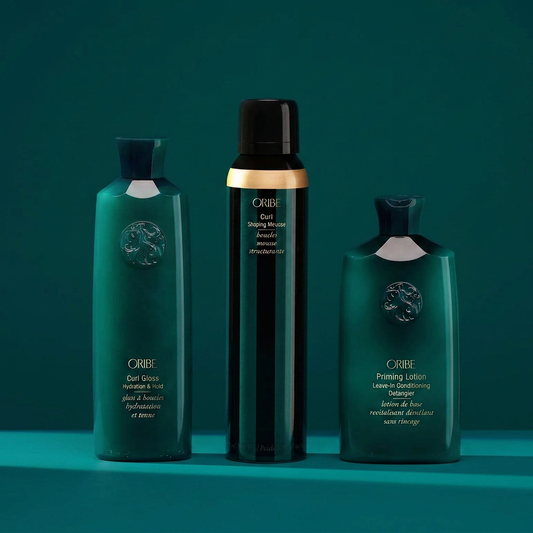 Oribe curl care set including Curl Gloss, Curl Shaping Mousse, and Priming Lotion Leave-In for defined, frizz-free curls
