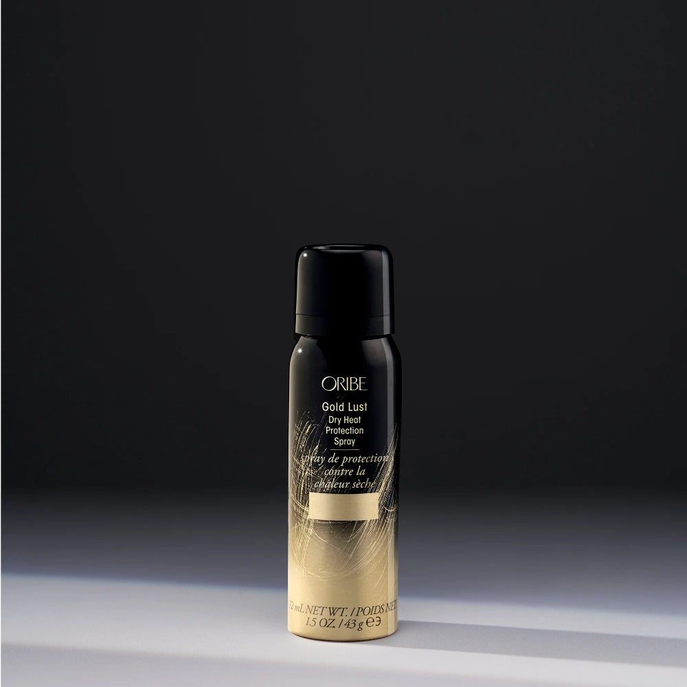 Award winning Gold Lust Dry Heat Protection Spray Travel Size on a dark background