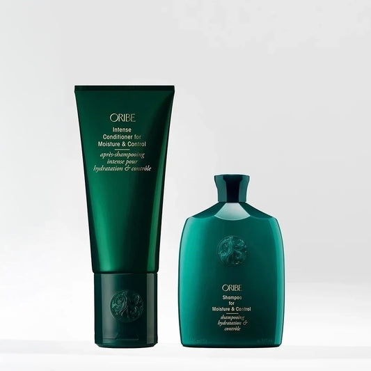 Oribe Intense Conditioner for Moisture & Control in a dark green squeeze tube next to Oribe Shine Moisture & Control in a matching dark green bottle, set against a light gray background.