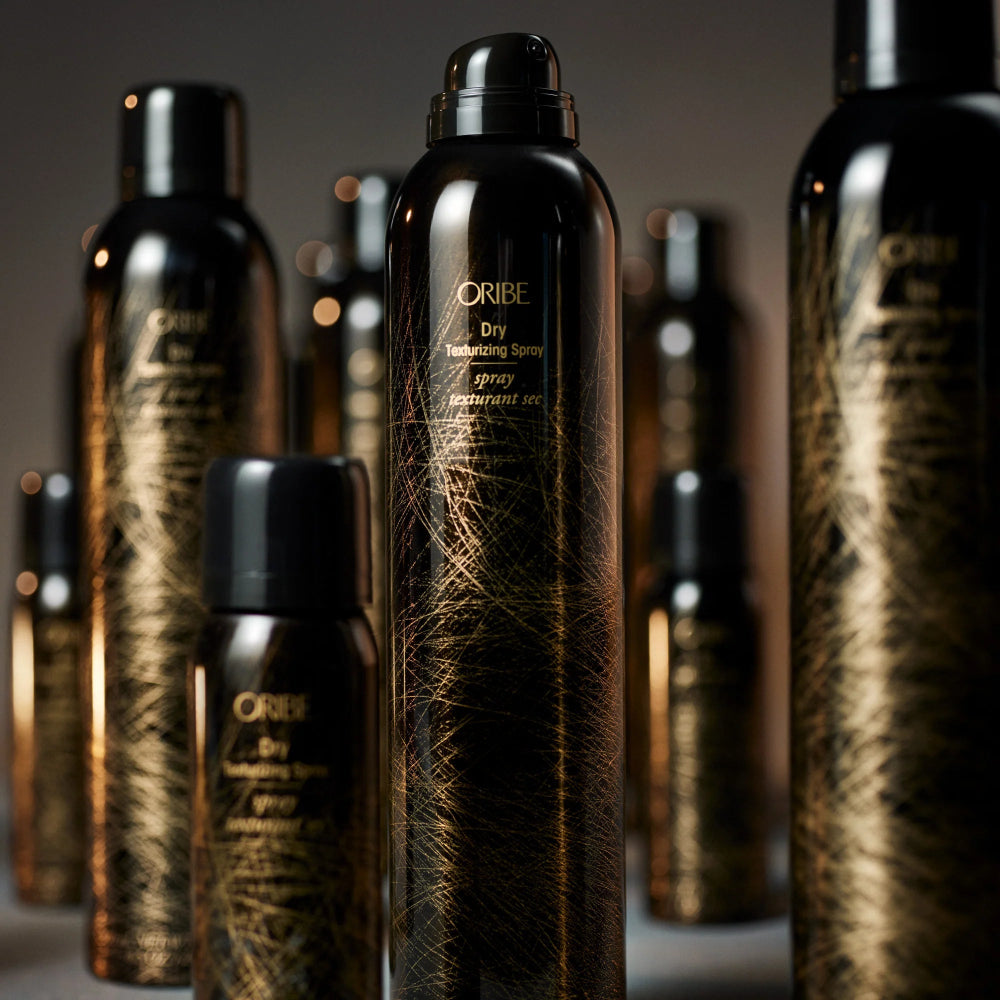 Multiple bottles of Oribe Dry Texturizing Spray arranged together showcasing the iconic styling product.