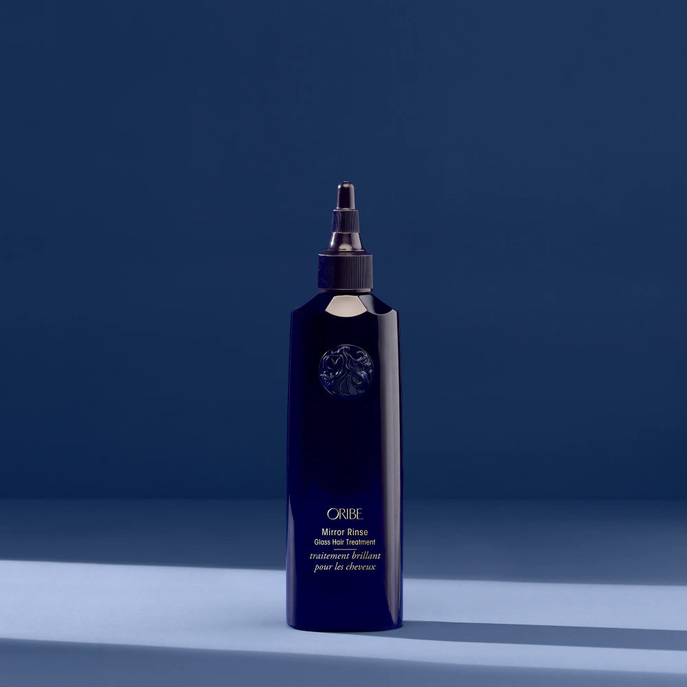 Oribe Mirror Rinse Glass Hair Treatment in deep blue bottle for high-shine, silky smooth hair
