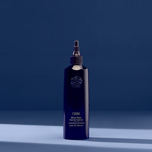 Oribe Mirror Rinse Glass Hair Treatment in deep blue bottle for high-shine, silky smooth hair