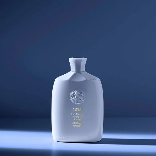 Oribe Run-Through Detangling Shampoo in light blue bottle for gentle cleansing and easy detangling
