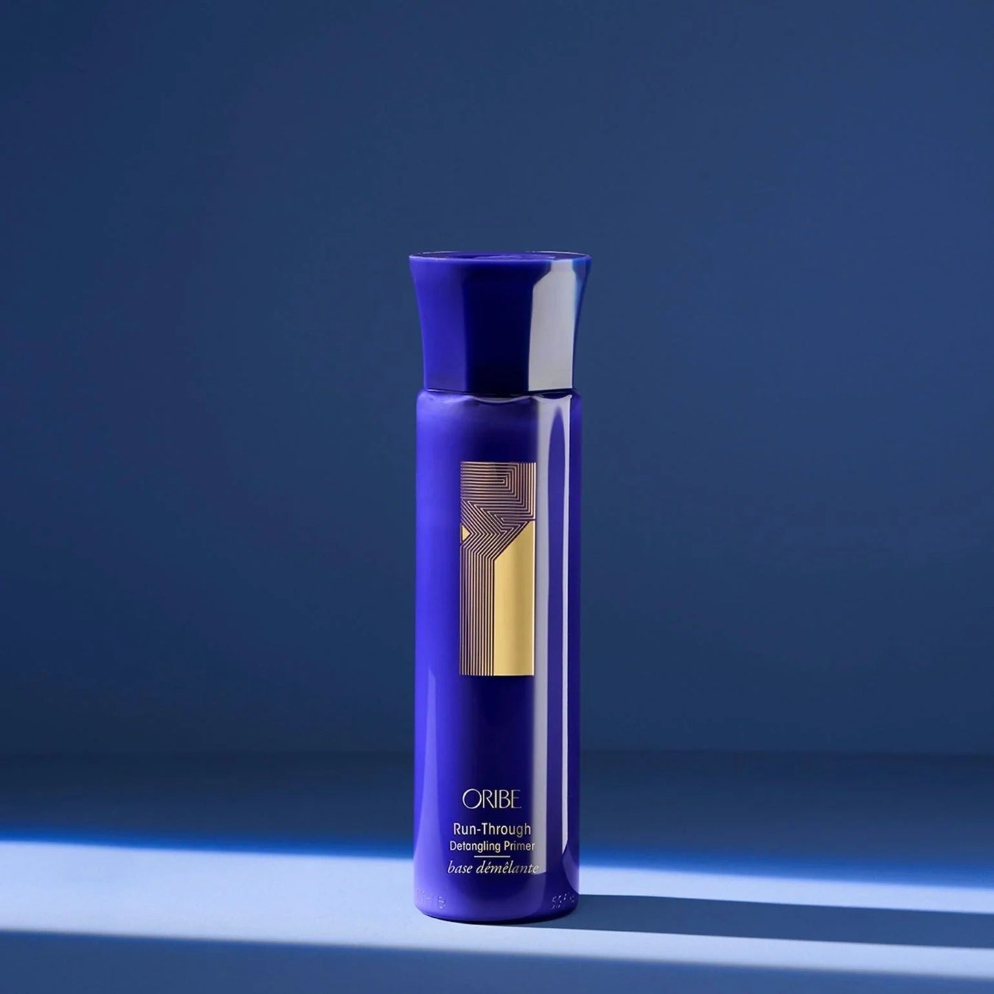 Oribe Run-Through Detangling Spray in blue bottle for effortless detangling and smooth, manageable hair