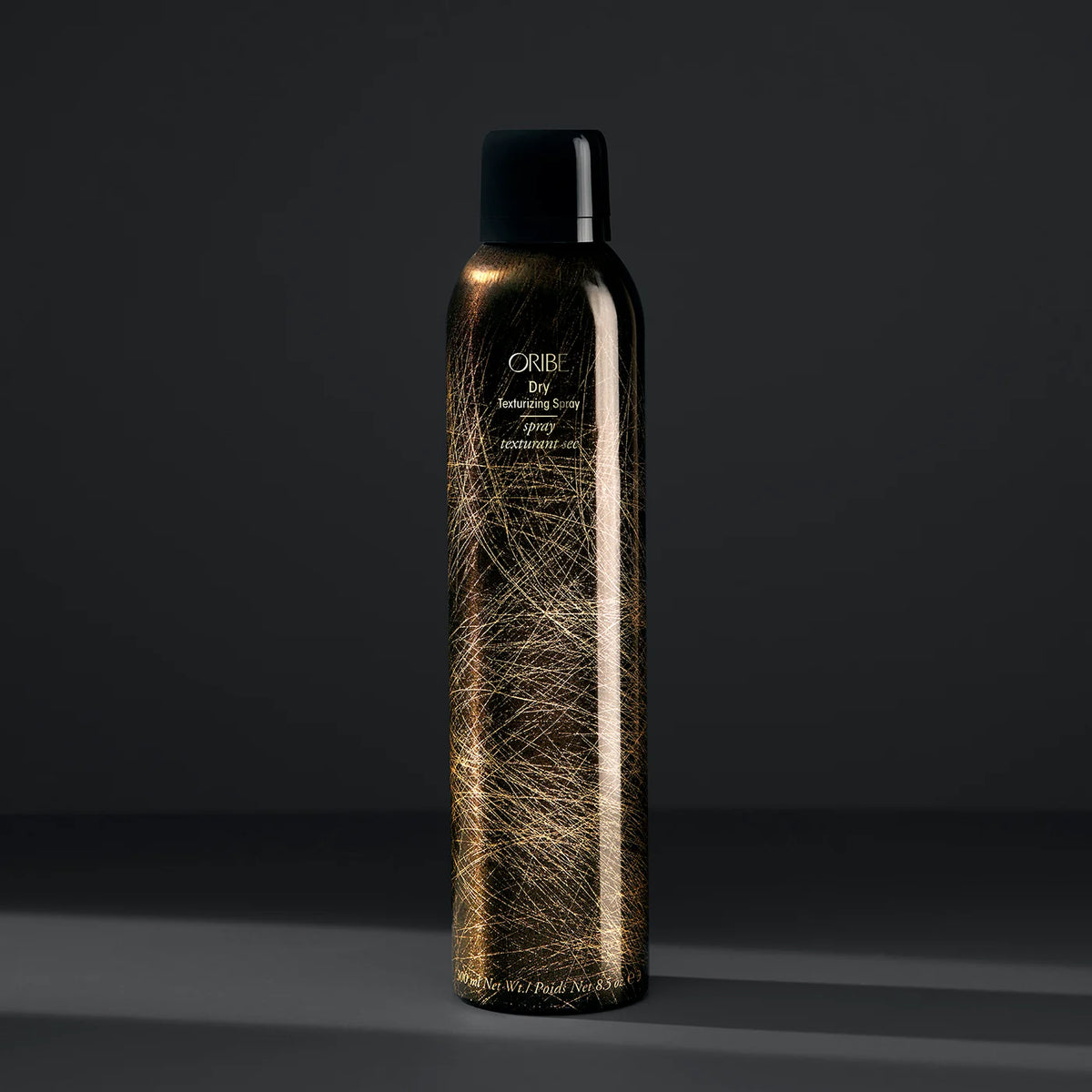 Oribe Dry Texturizing Spray in signature black and gold aerosol bottle, a volumizing styling spray for added texture and fullness.