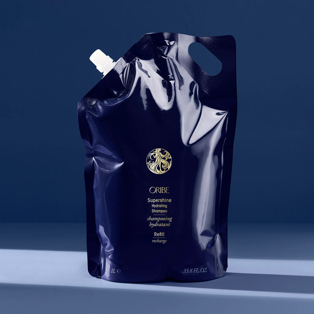 Oribe Supershine shampoo refill pouch on a blue background