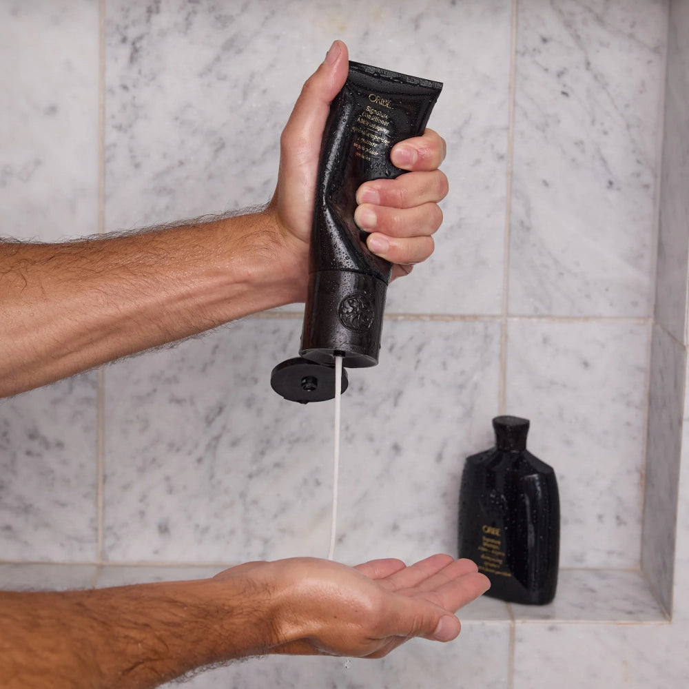 Applying Oribe Signature Conditioner for smooth detangled and healthy hair