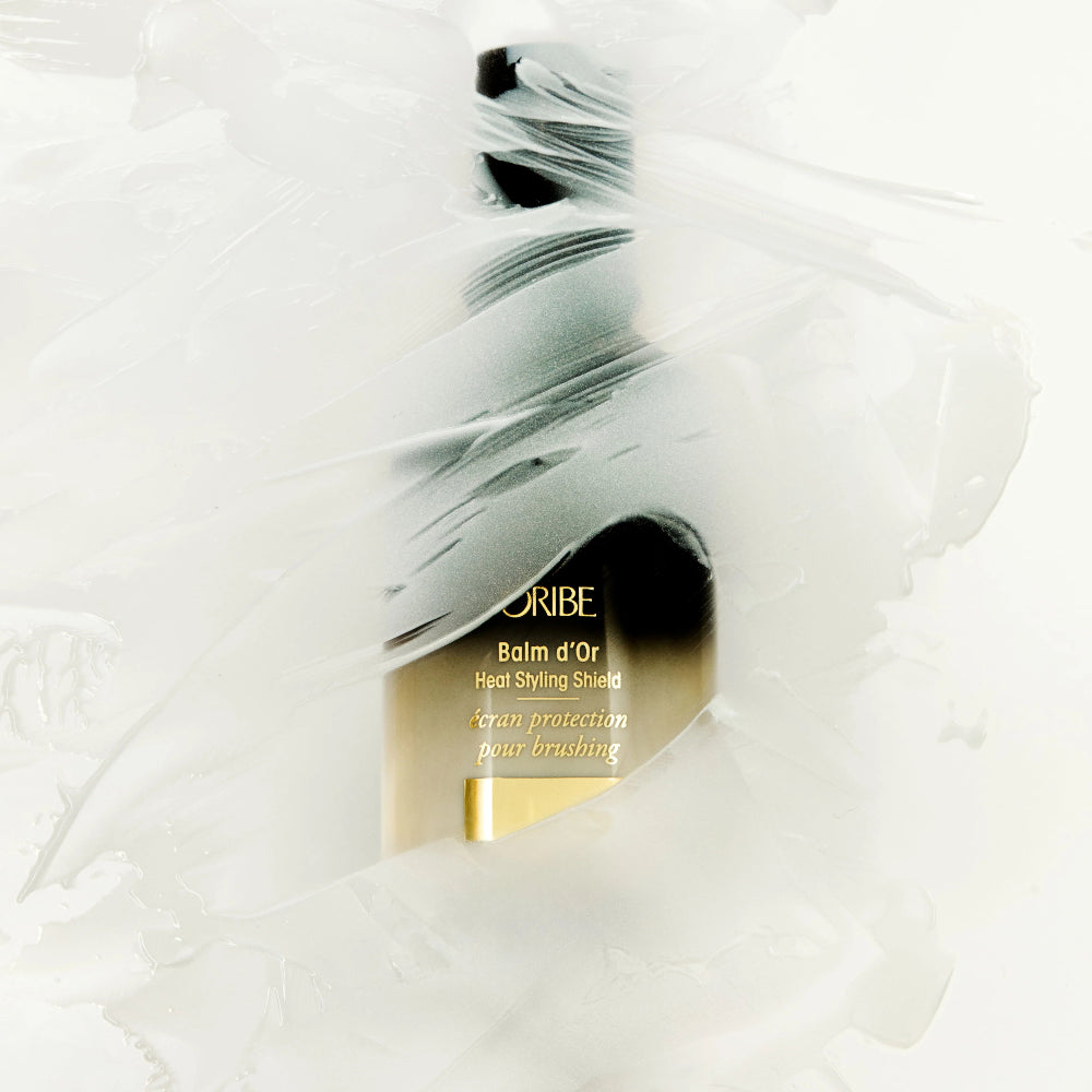 applying Oribe Balm d’Or Heat Styling Shield to protect hair from heat damage
