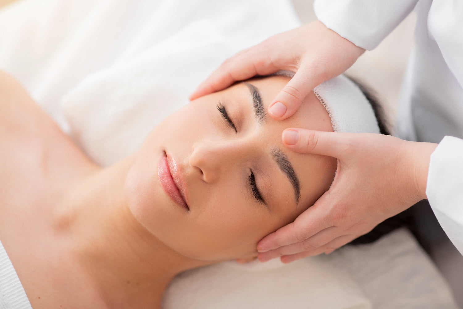 Person receiving a facial massage with a focus on skincare and wellness.