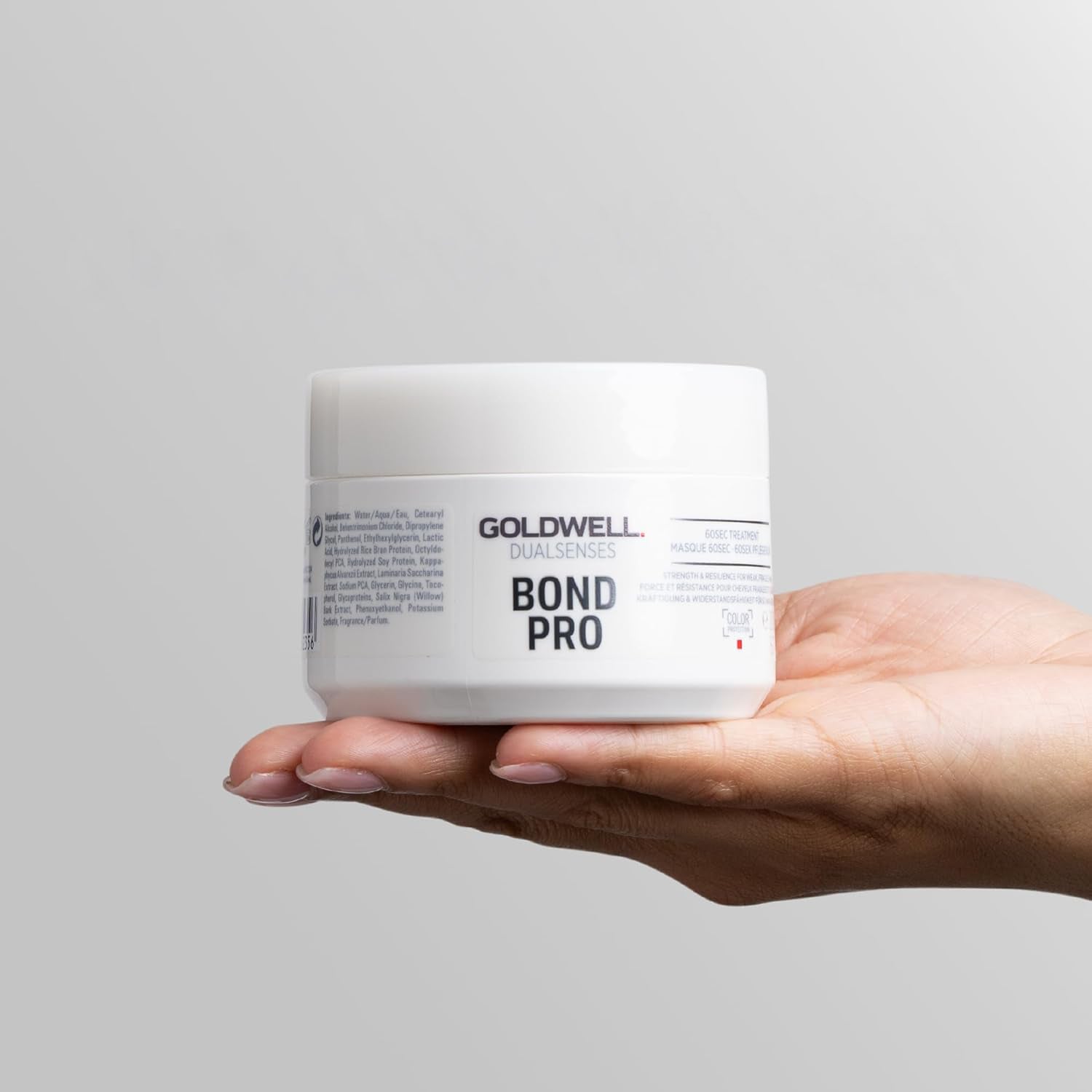 hand holding Goldwell Dualsenses Bond Pro 60Sec Treatment jar for quick intensive strengthening care