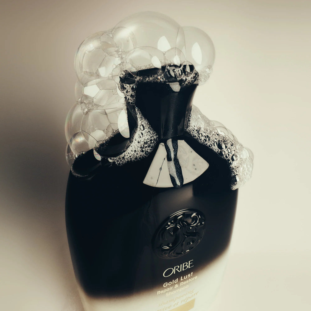 Oribe Gold Lust shampoo luxury packaging highlighting premium hair care