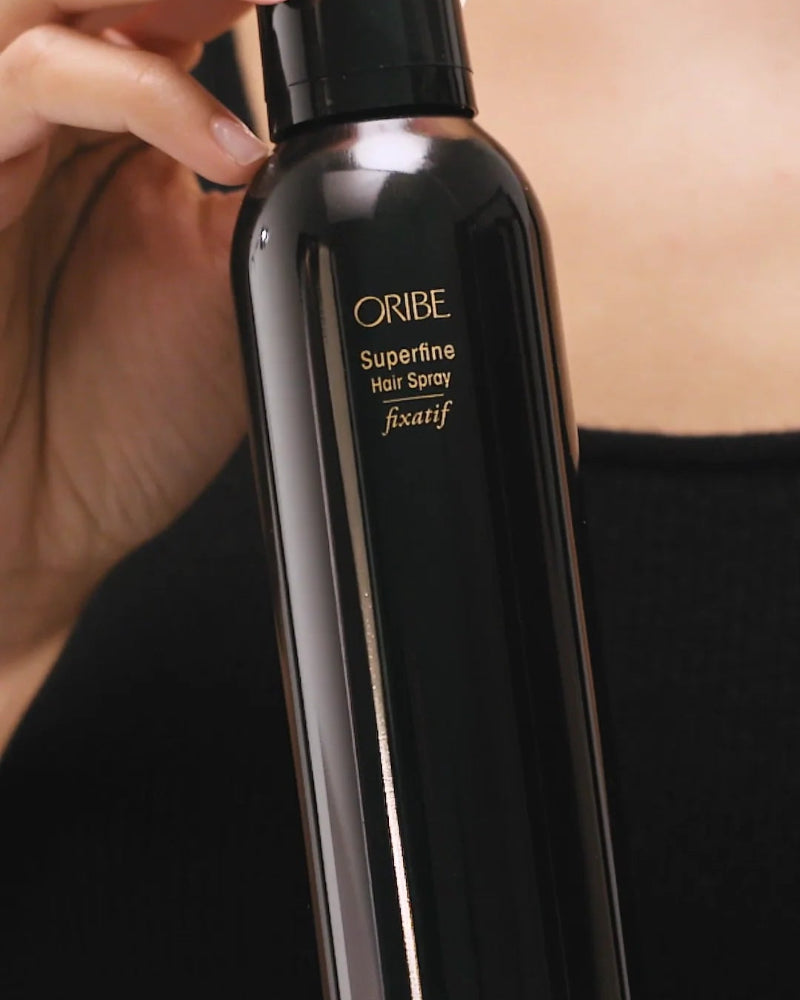 close up of woman holding Oribe Superfine Hairspray