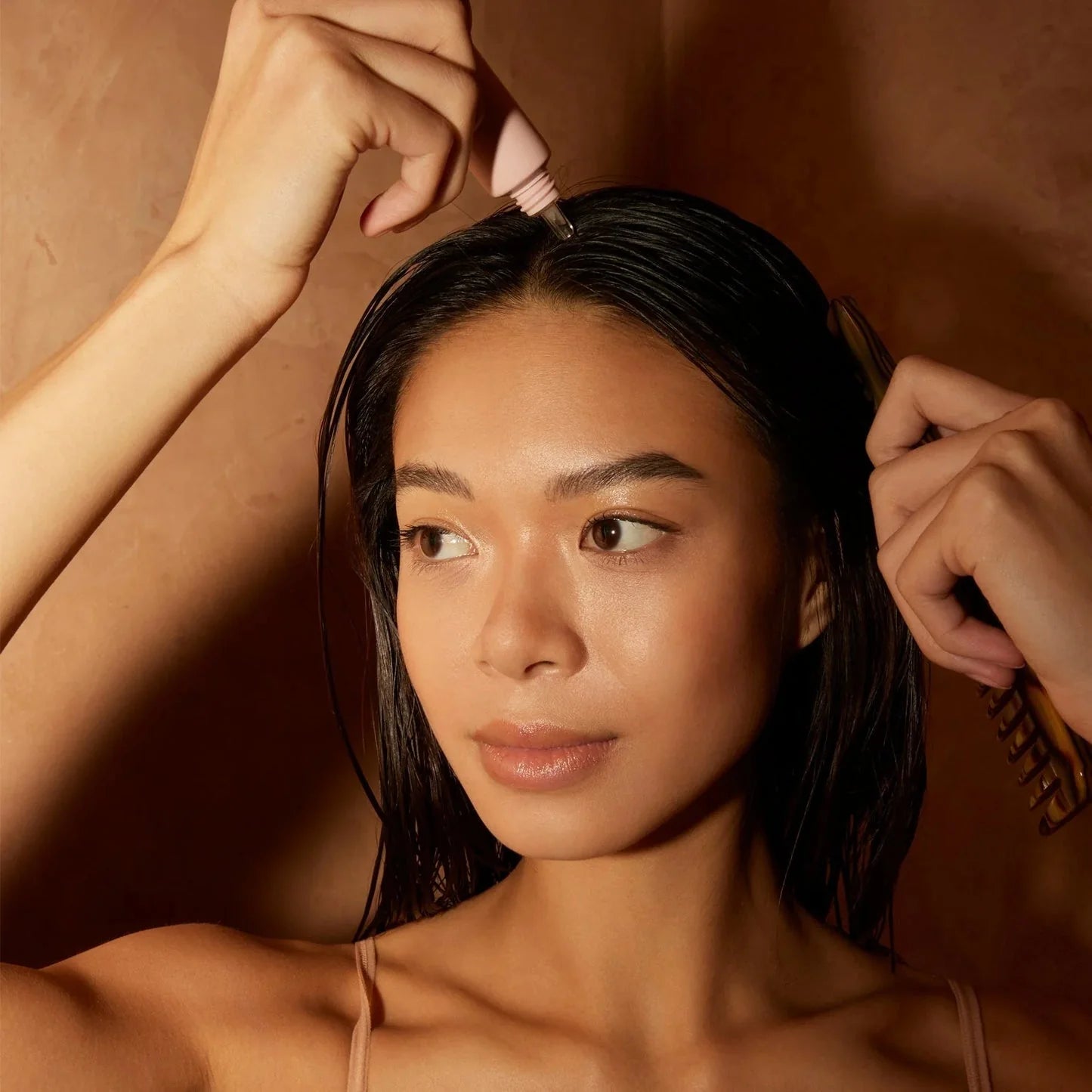 applying Oribe Serene Scalp leave-on treatment to soothe dry irritated scalp and improve comfort