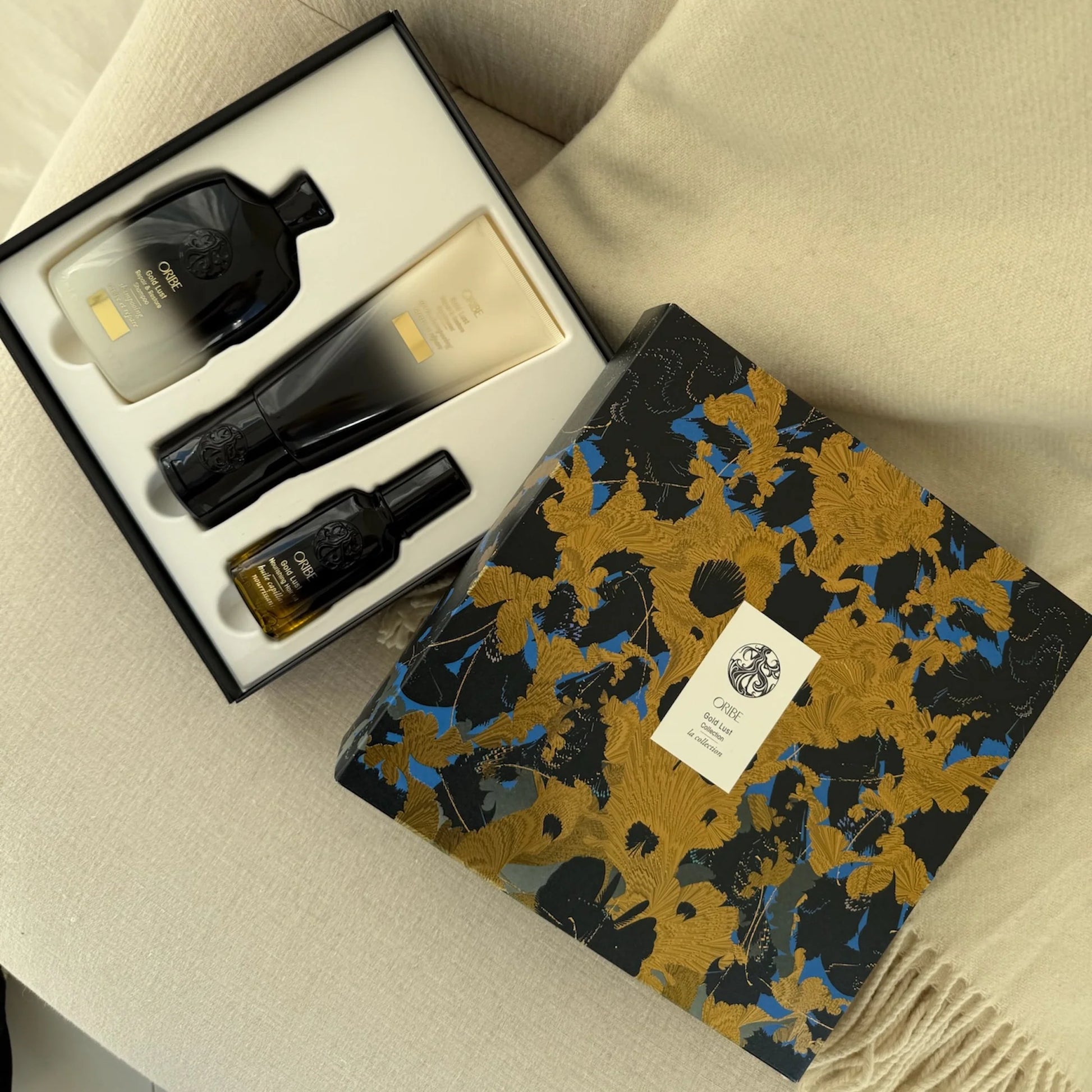 Opened Oribe Gold Lust luxury haircare gift set featuring shampoo conditioner and hair oil