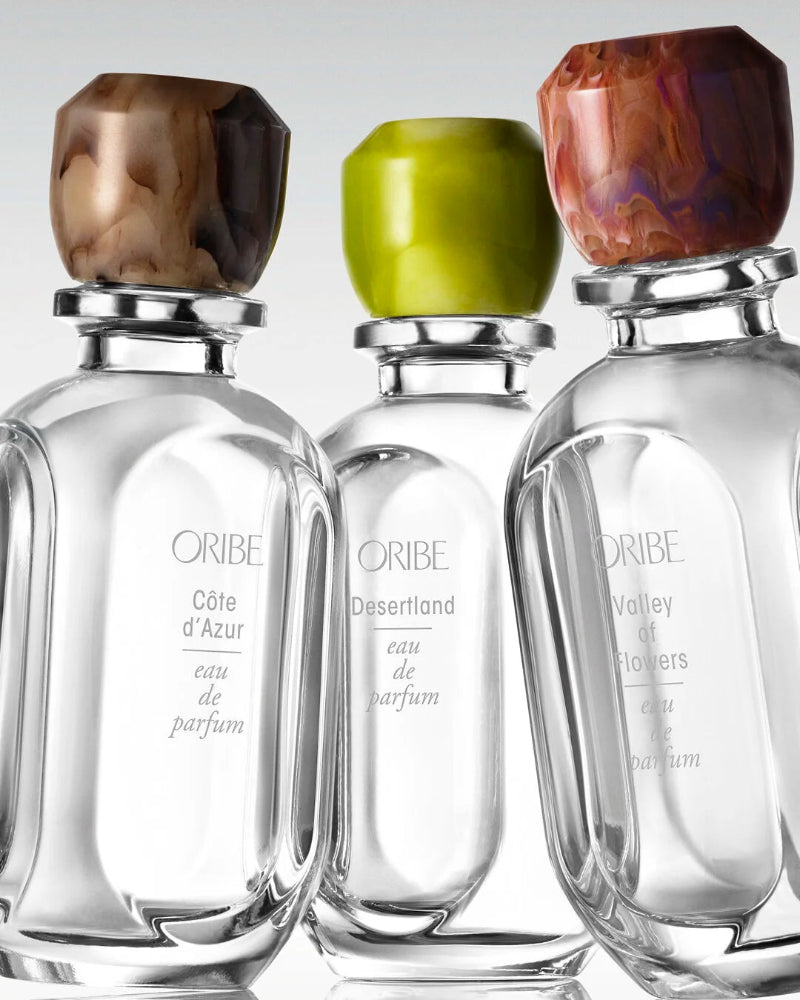 Oribe eau de parfum collection featuring Côte d’Azur, Desertland, and Valley of Flowers fragrances with signature sculpted caps.
