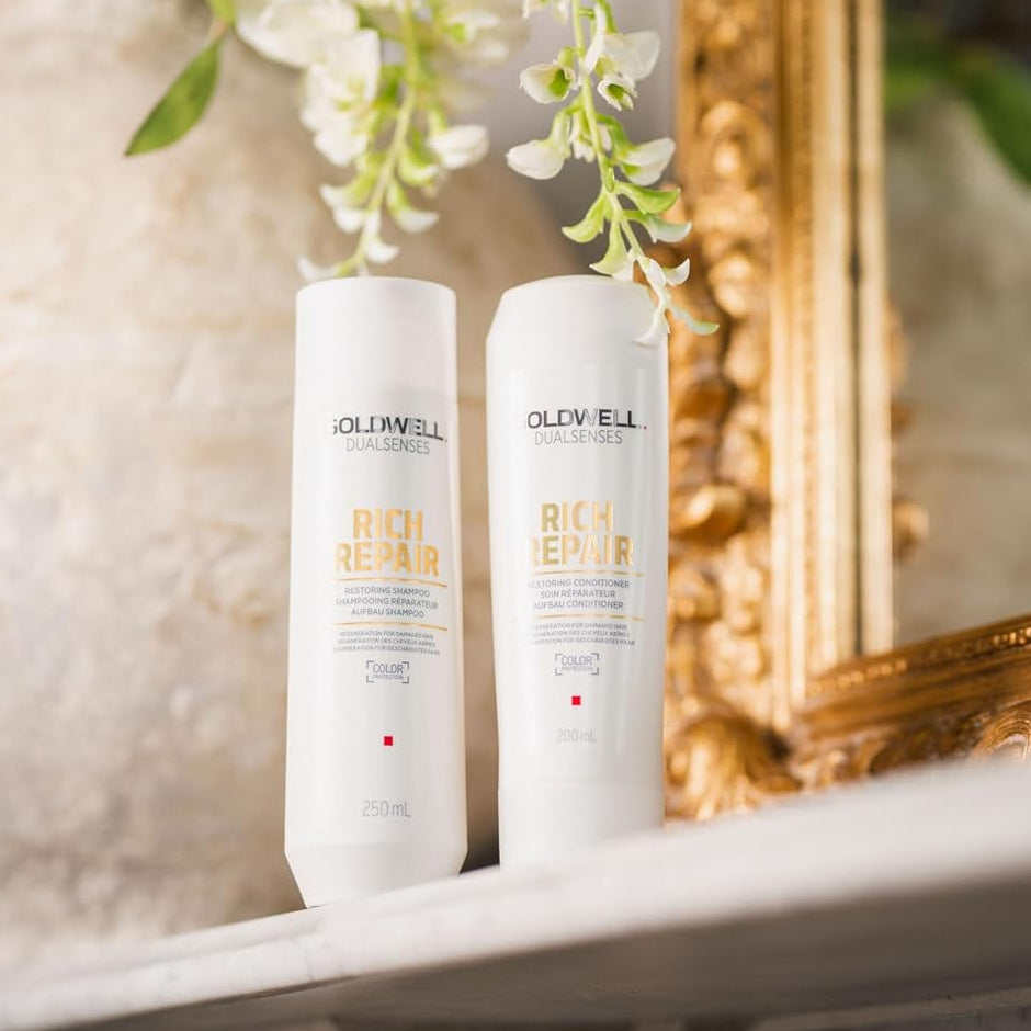 Goldwell Rich Repair shampoo and conditioner displayed in bathroom for professional hair repair routine