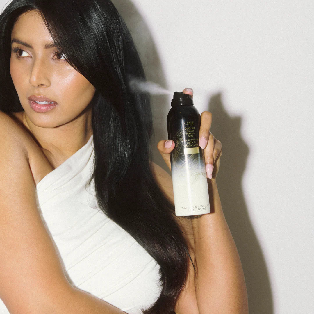 applying Oribe heat protection spray before styling to prevent heat damage